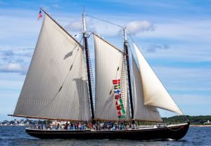 Schooner Adventure vessel with sails raised, view with flags from the side.